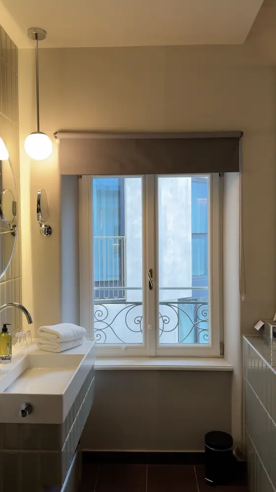 Large bathroom window beside the basin, with a neighbouring building visible outside.