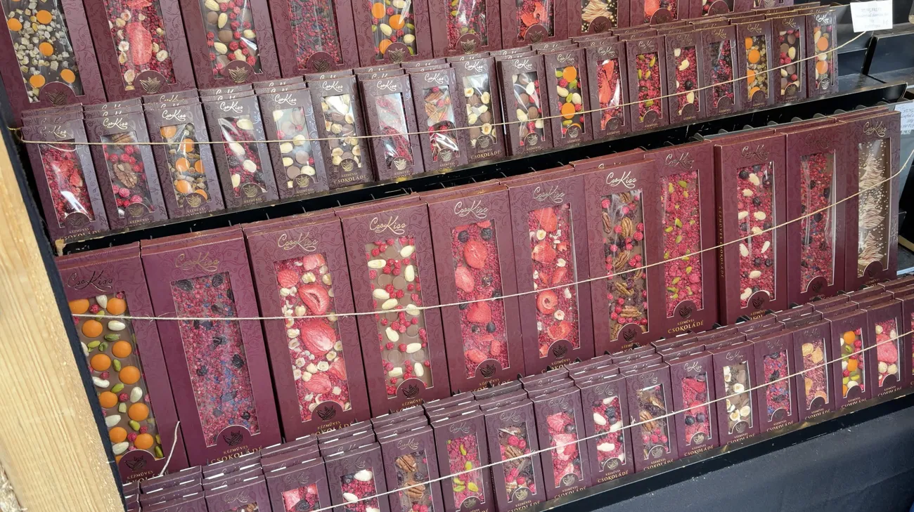 Rows of chocolate bars in red and gold wrapping on display shelves.