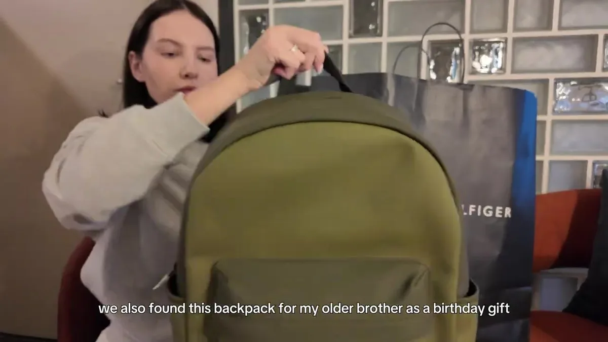 Me showing an olive Tommy Hilfiger backpack with a front zip pocket.