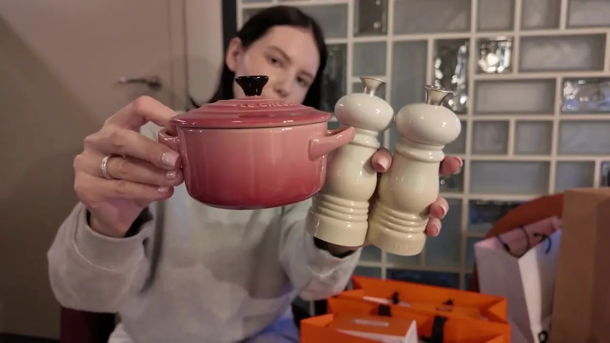 Me holding a pink Le Creuset mini cocotte and two light-cream salt-and-pepper mills.