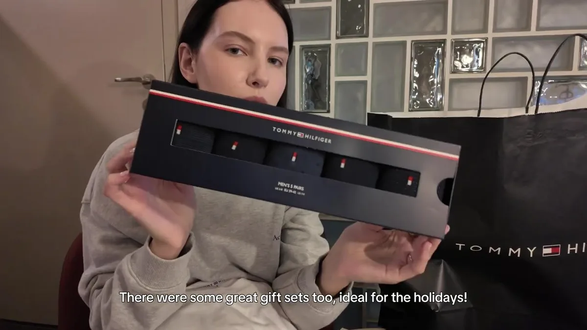 Me holding a boxed Tommy Hilfiger set containing five pairs of men’s socks.