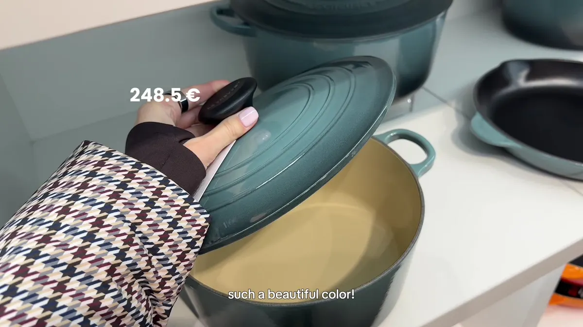 Green Le Creuset pot with its lid lifted and an on-screen price of €248.50.