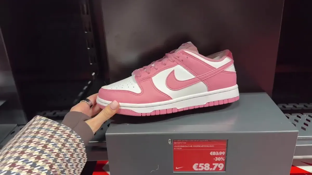 Pink-and-white Nike Dunk Low Next Nature beside a sale label showing €58.79 from €83.99.