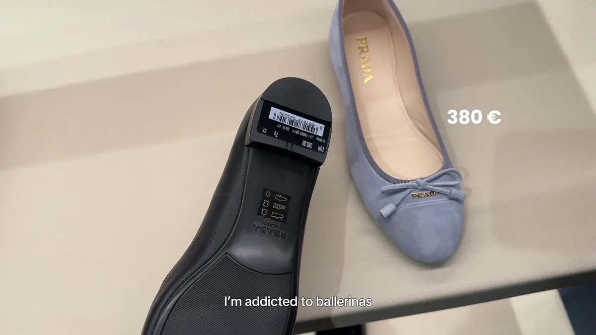 Prada ballerinas in black and pale blue, with a €380 label on the shown black shoe.