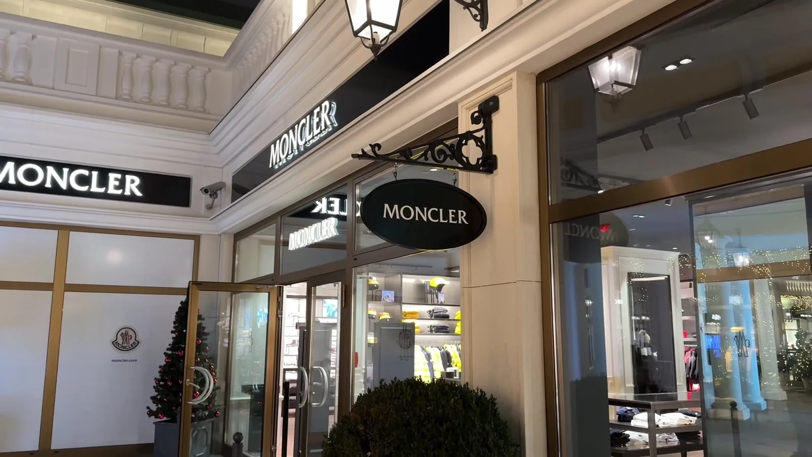 Moncler storefront at Designer Outlet Parndorf, with illuminated signs and a small Christmas tree by the entrance.
