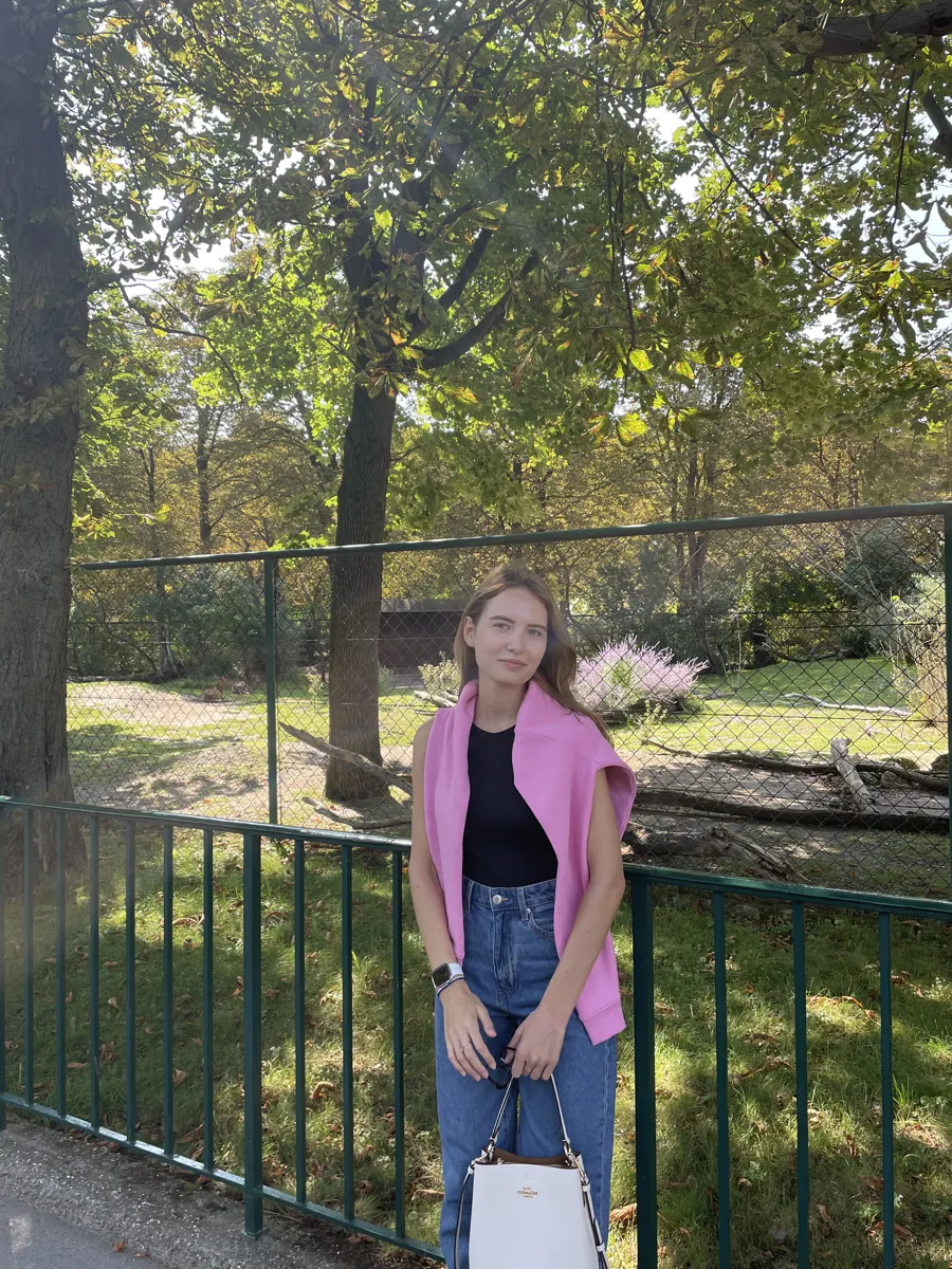 Me beside a leafy enclosure at the zoo